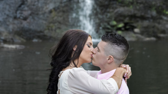 couple kissing by waterfall