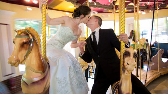 photography bride and groom kissing on merry go round carousel