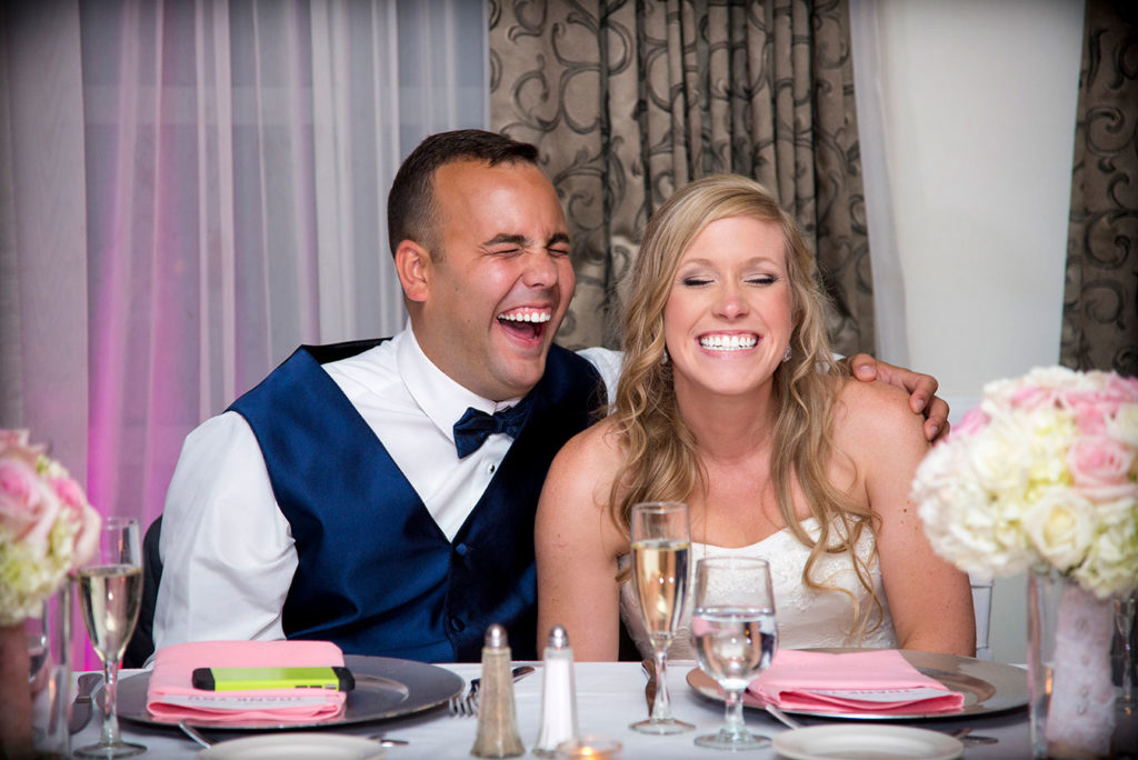 photography bride and groom laughing at table during ceremony