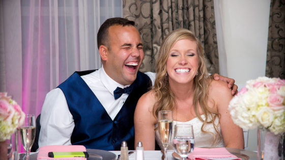 photography bride and groom laughing at table during ceremony