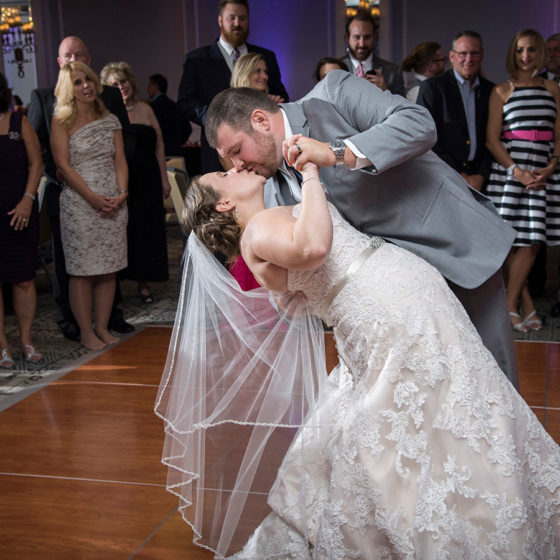 photography bride and groom kissing during first dance as guests watch